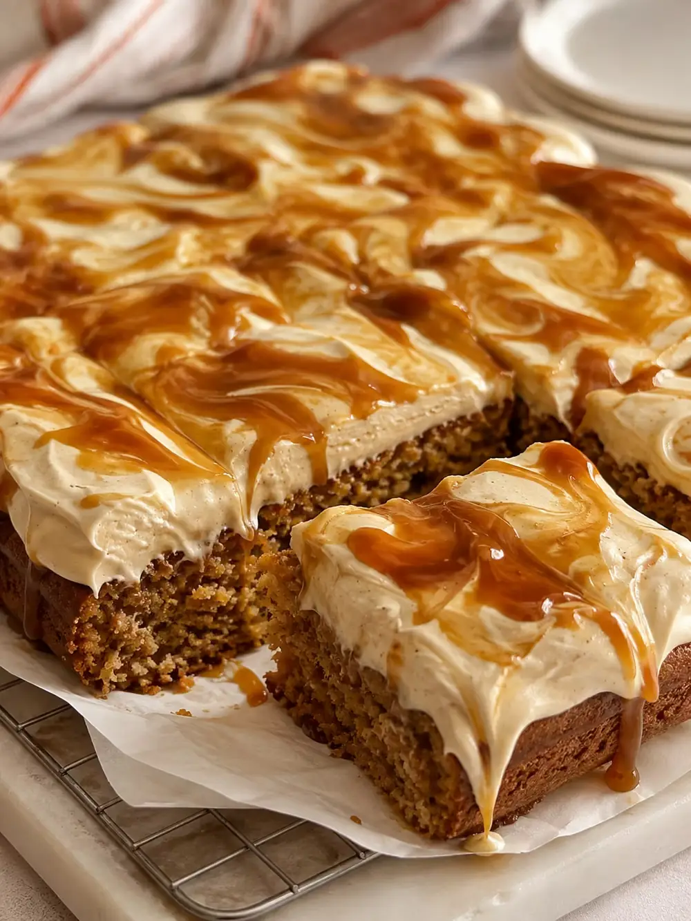 Caramel carrot sheet cake cut into squares showing swirled caramel cream cheese frosting